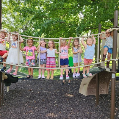 Our 2023-2024 three and four year old class outside enjoying the playground!