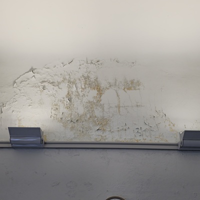 Extensive damage on interior wall near curved ceiling (east side)